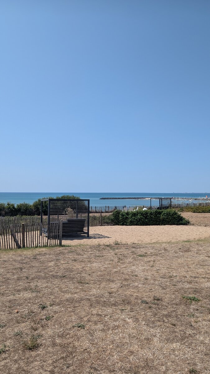 Dunes et cabanes ouvertes sur l'horizon marin